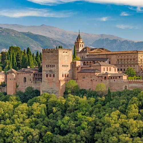La Alhambra de Granada entre bosques con Sierra Nevada al fondo