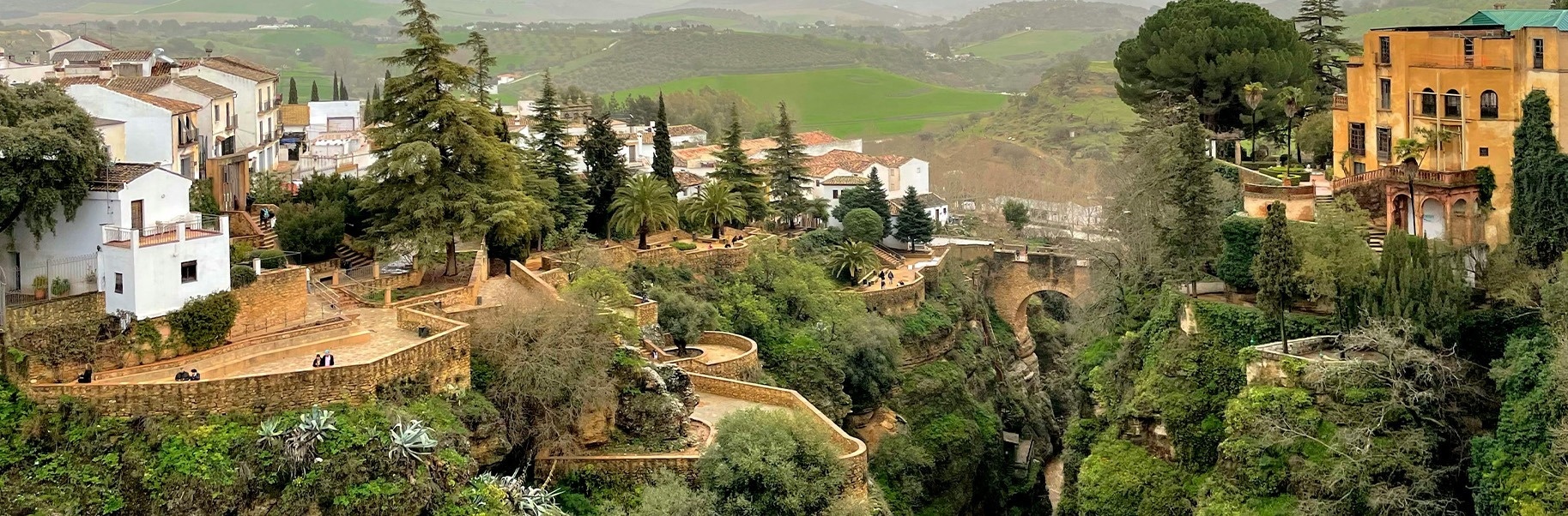 un pueblo en la ladera de una colina rodeado de árboles y edificios