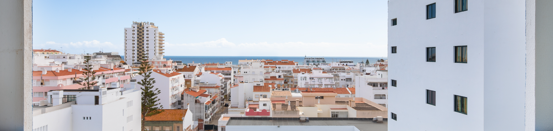 uma janela com vista para a cidade e o oceano