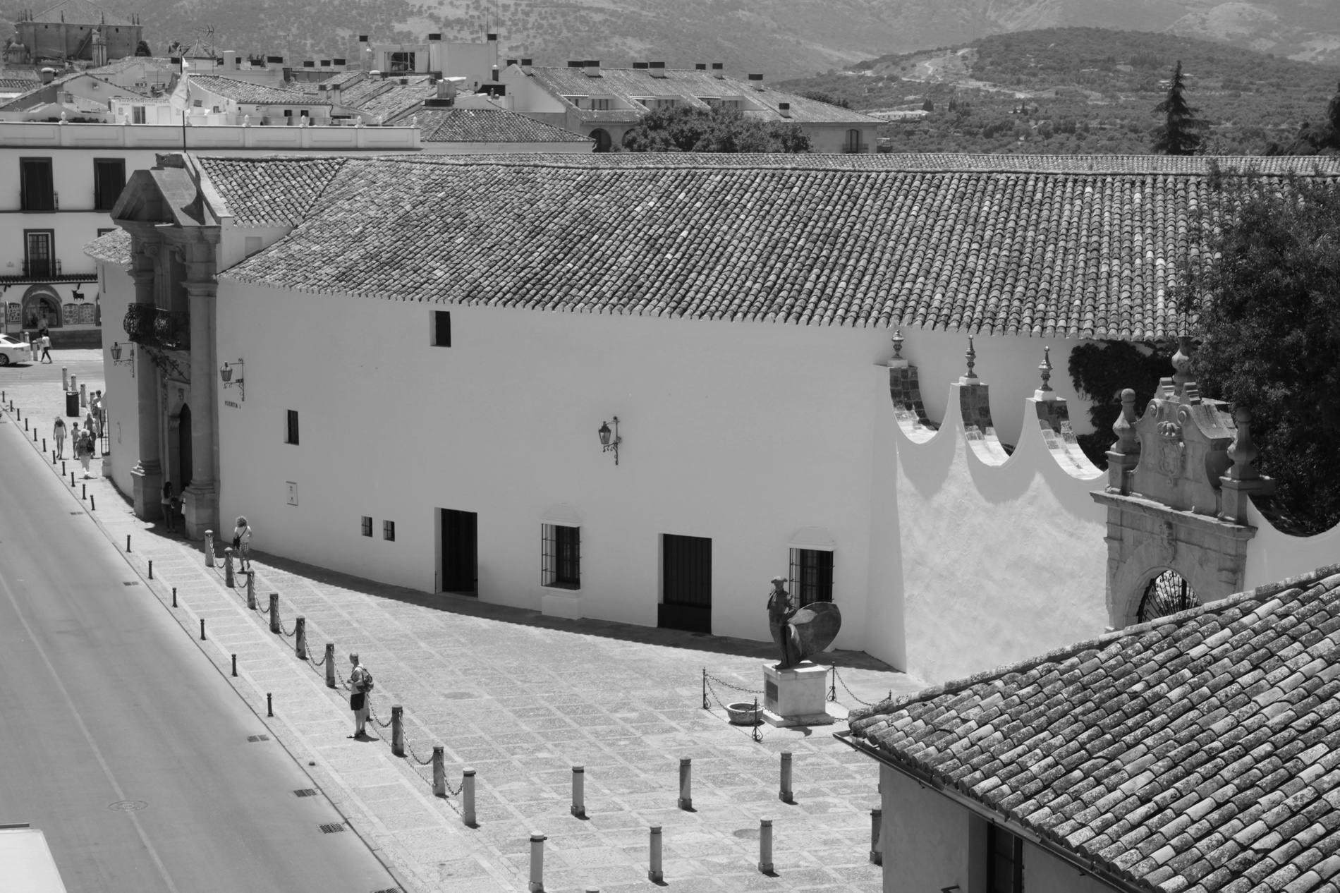 a black and white photo of a white building with a tiled roof=s1900