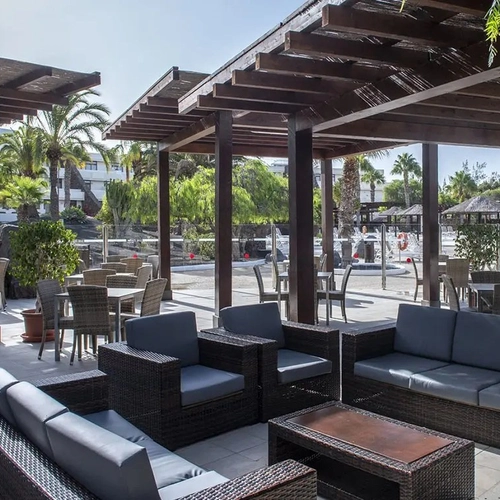 Terraza con sofás bajo pérgolas de madera en Los Zocos Impressive Lanzarote