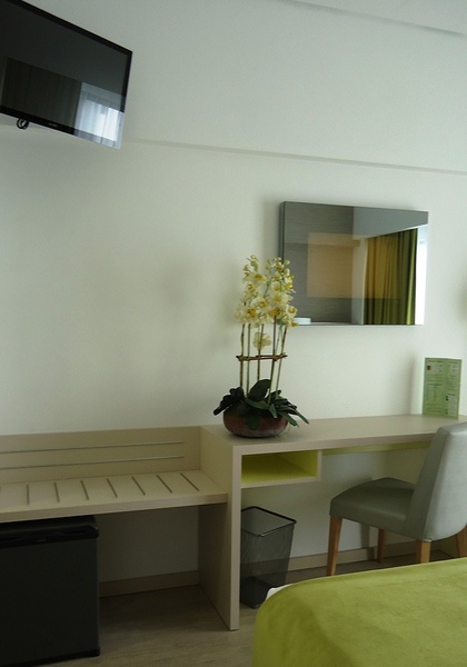 uma cama em um quarto de hotel com um travesseiro verde