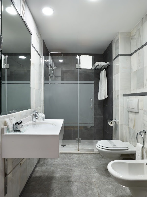 a bathroom with a sink toilet and bidet