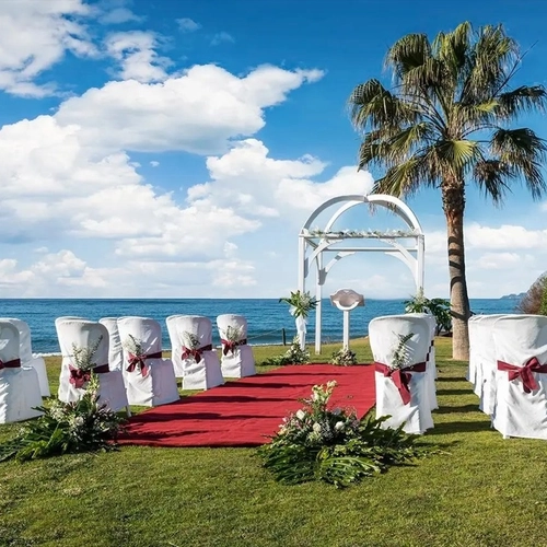 Ceremonia de boda junto al mar con alfombra roja y arco blanco en Impressive Playa Granada Golf
