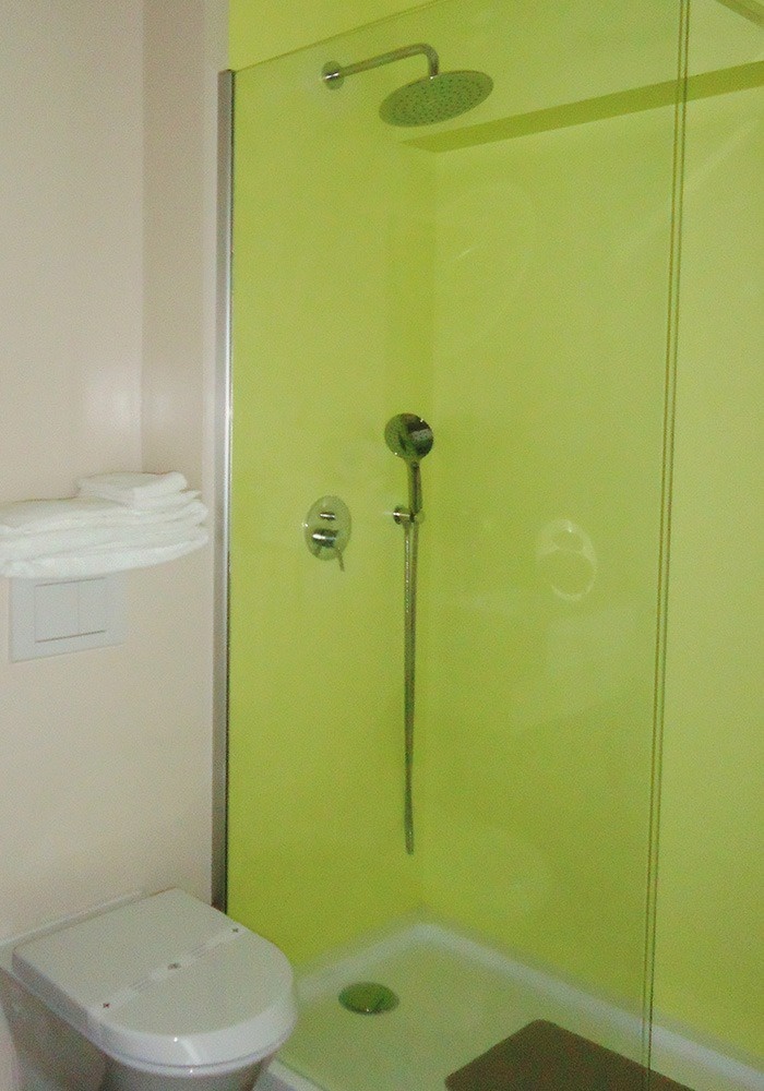 a bathroom with a green shower and a toilet