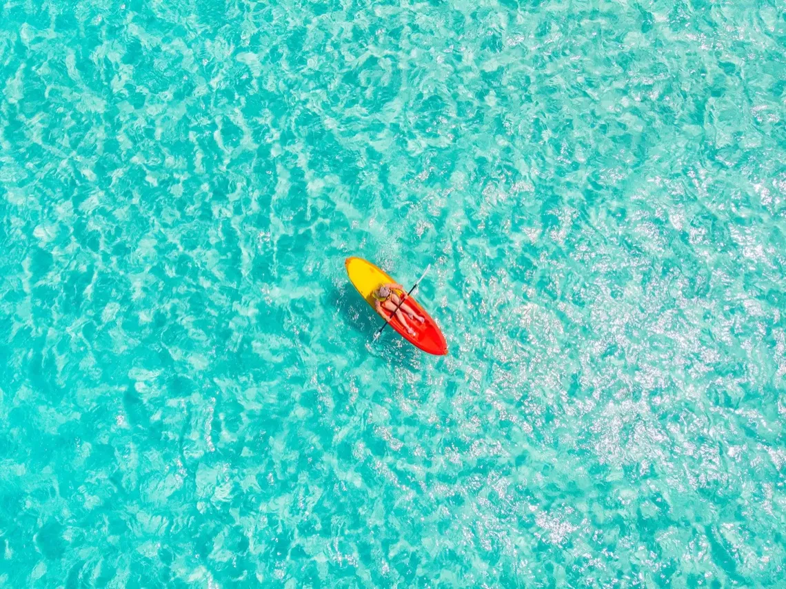Kayak sobre aguas turquesas visto desde arriba