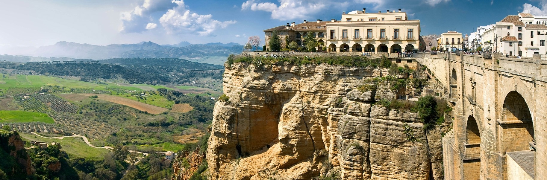 a large building sits on top of a cliff overlooking a valley