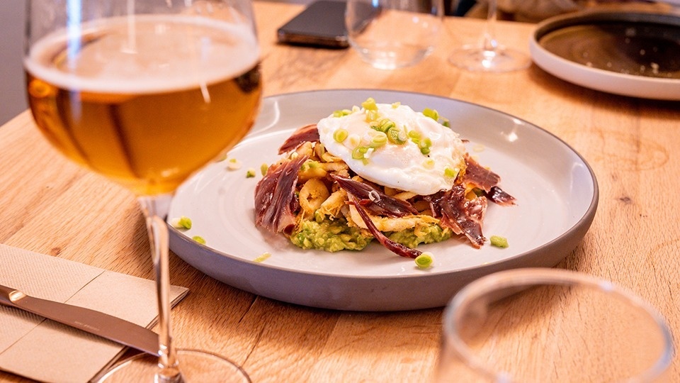 a plate of food next to a glass of beer