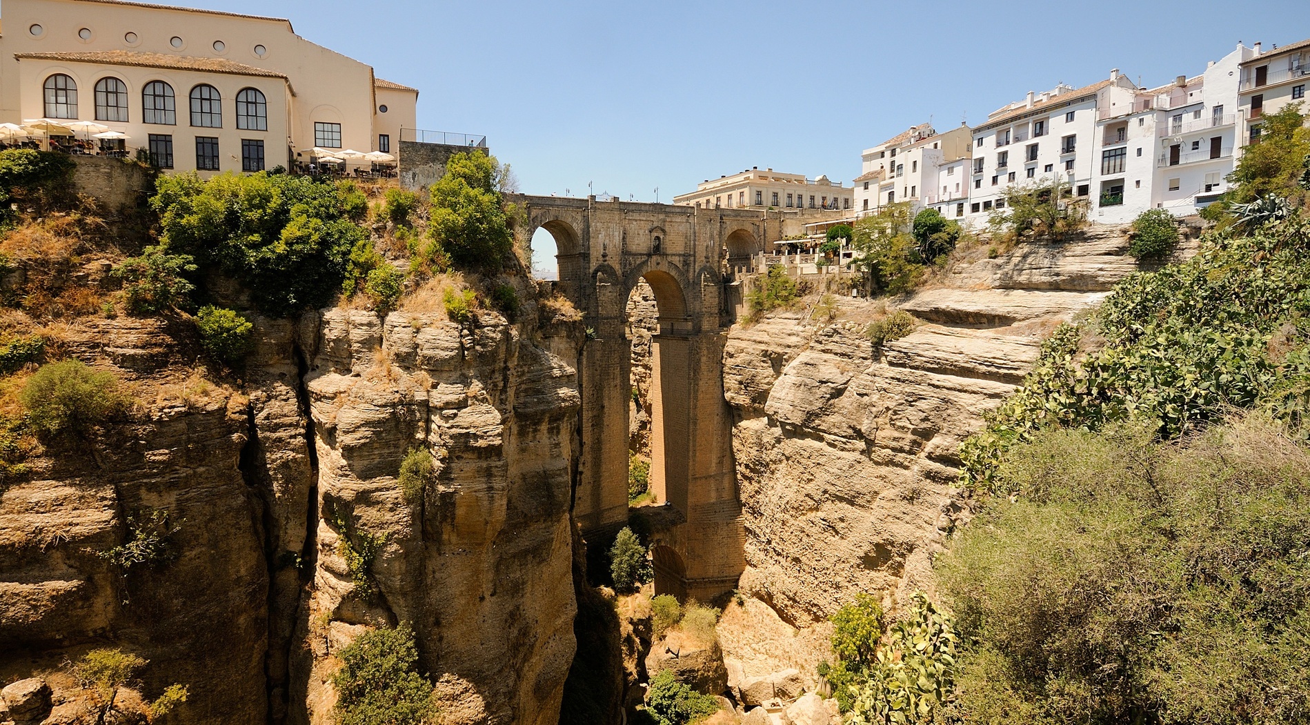 a bridge over a canyon with a building in the background