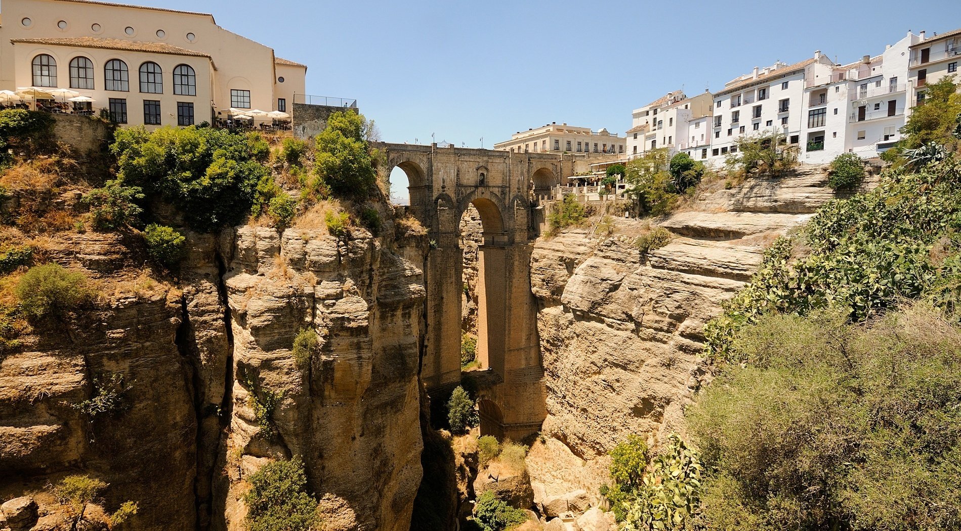 un puente sobre un cañón entre dos edificios blancos