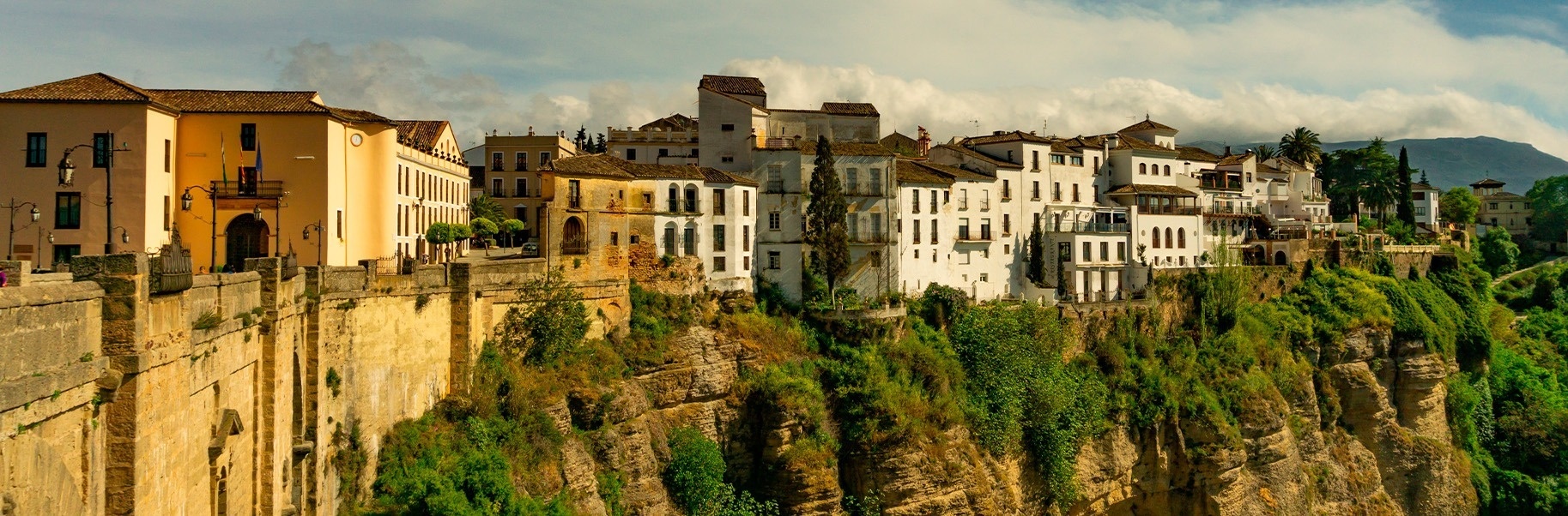 a row of buildings on the side of a cliff with a sign that says ' ayuntamiento ' on it