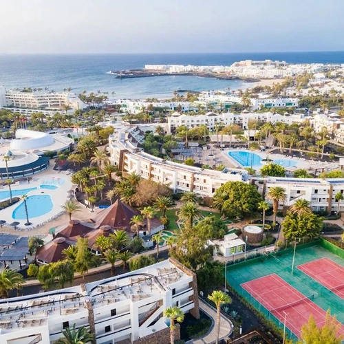 Vista aérea de Los Zocos Impressive Lanzarote con piscinas, pistas de tenis y el mar