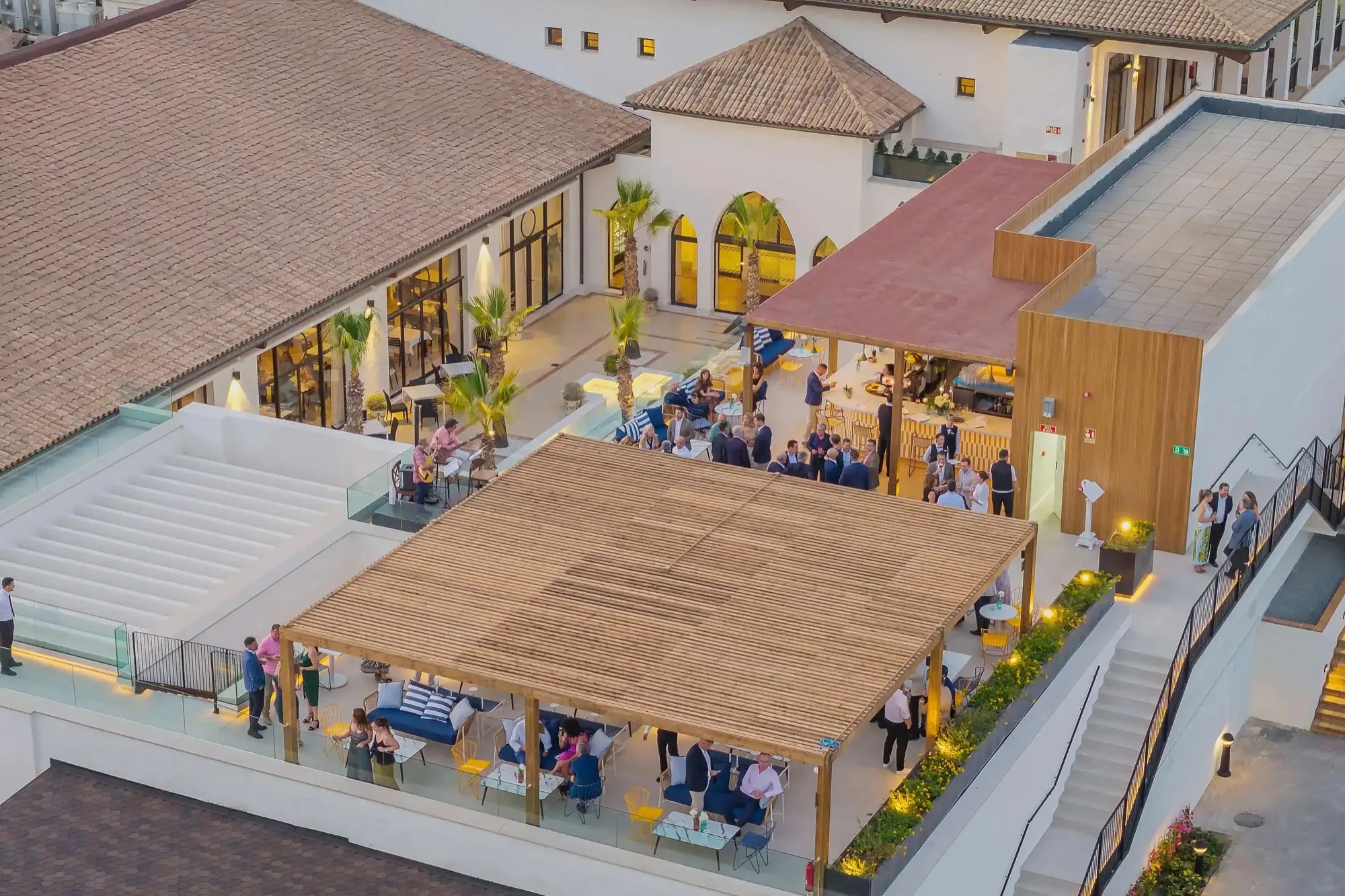 Hotelterrasse mit Gästen, die Livemusik an der Bar genießen