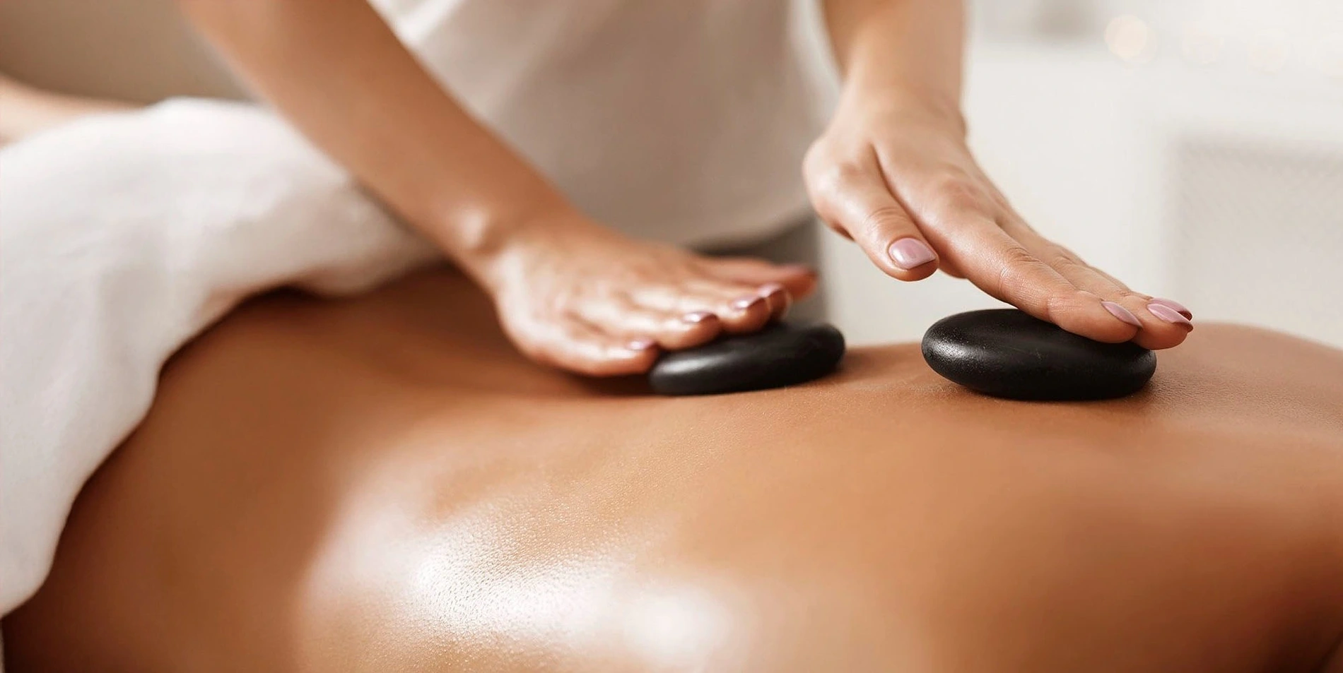 Masaje con piedras calientes sobre la espalda en el spa