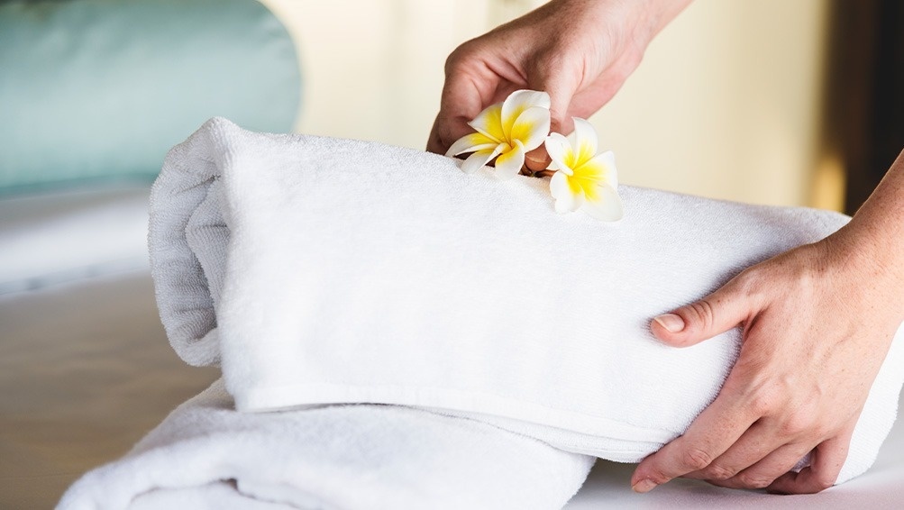 a person is putting flowers on top of a towel
