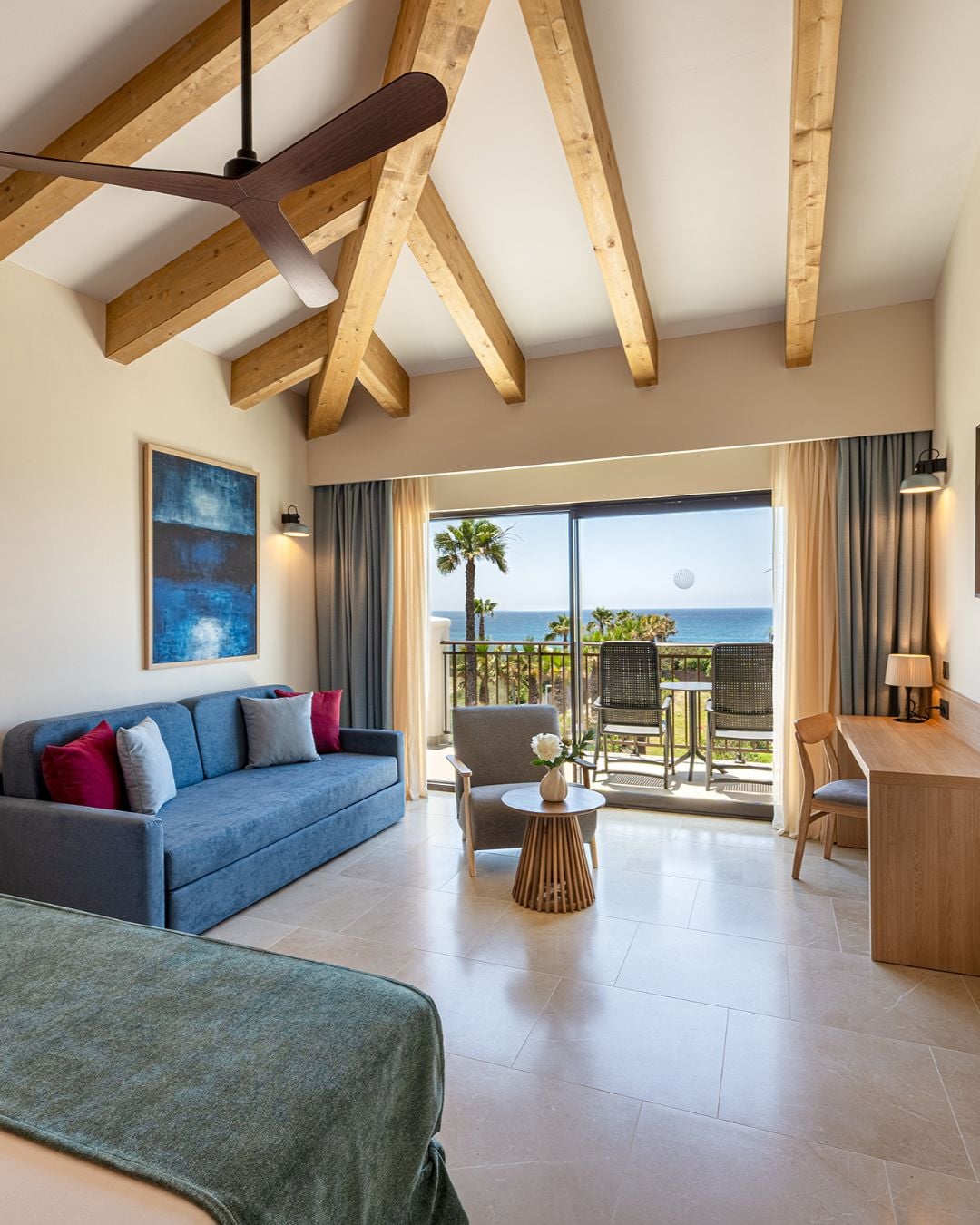 Suite mit Bett und blauem Sofa, Meerblick und Balkon