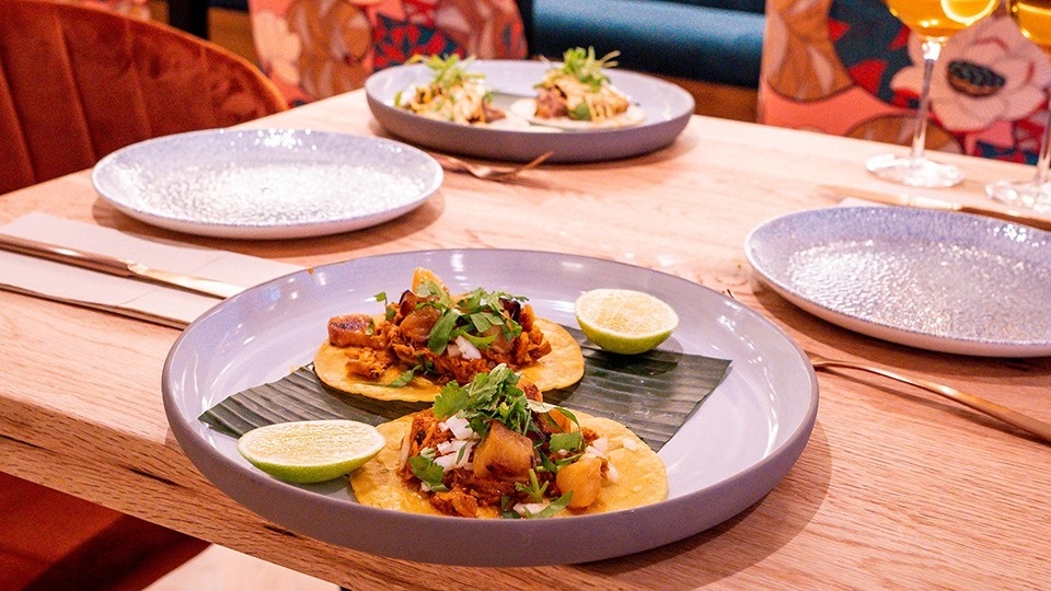 three plates of food are on a wooden table