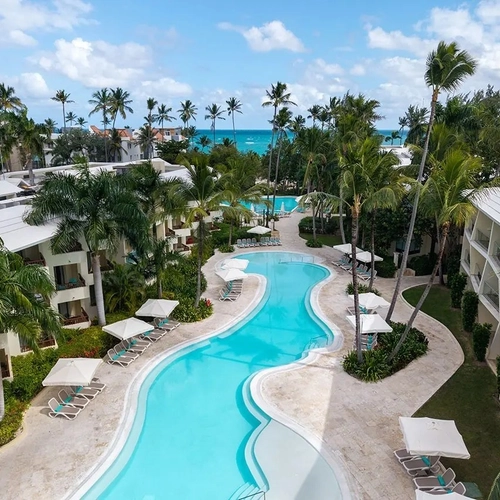 Vista aérea de la piscina entre palmeras y edificios de Impressive Premium Punta Cana
