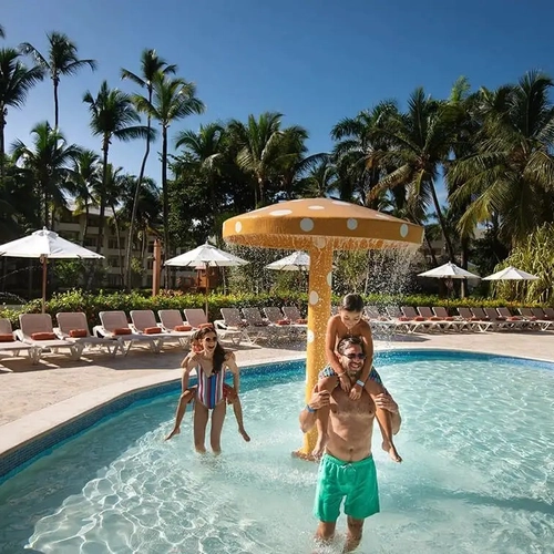 Familia en la piscina infantil con fuente en forma de seta en Impressive Punta Cana