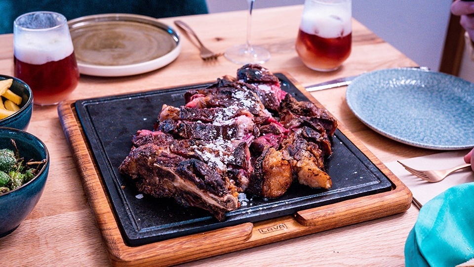 a large piece of meat is sitting on a wooden cutting board that says cava