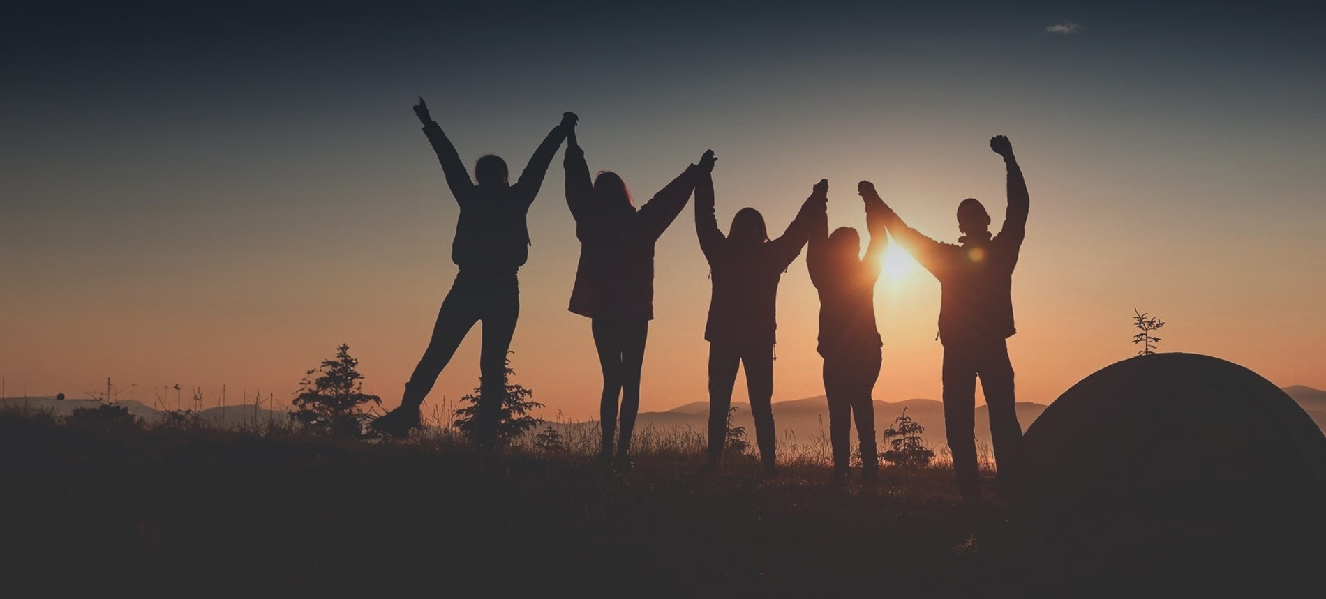 a group of people holding hands in front of a tent