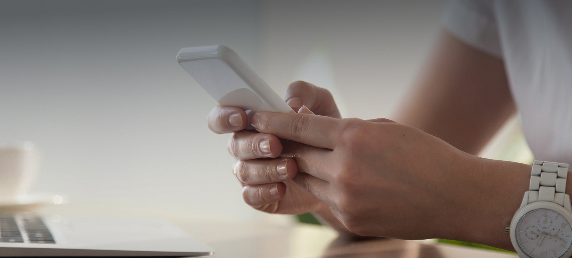 a woman wearing a watch is using a cell phone