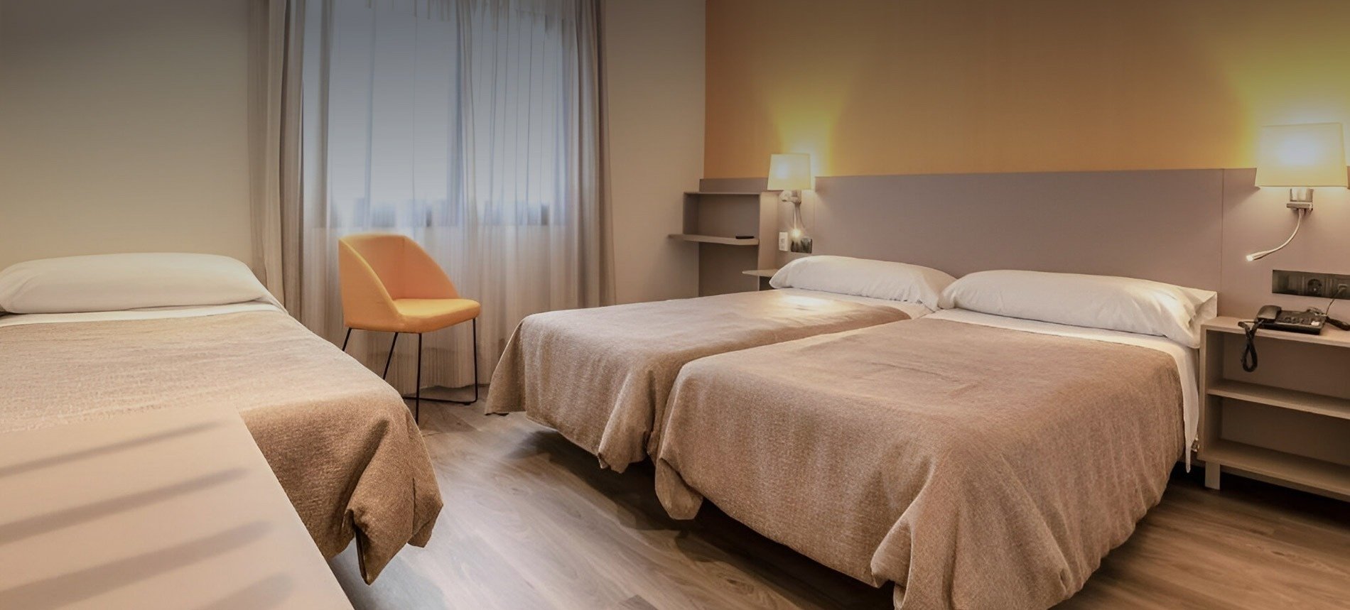 a bed with yellow pillows and a yellow chair in a hotel room