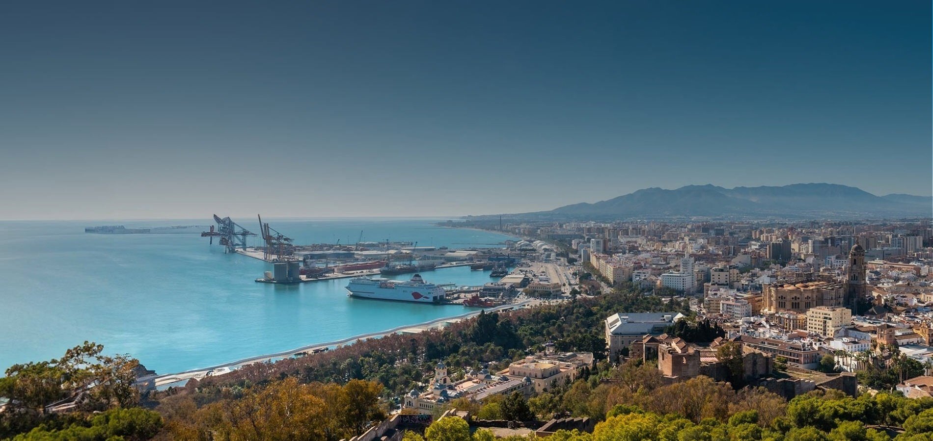 an aerial view of a city with a large ship in the water