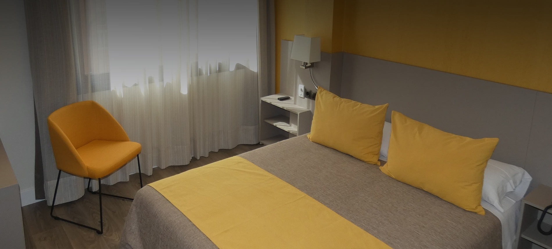 a hotel room with yellow pillows and a yellow chair