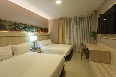una habitación de hotel con dos camas y una televisión - 