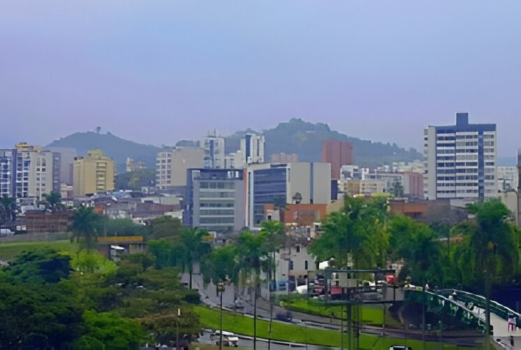 palmeras y montañas en un día nublado con un cielo azul