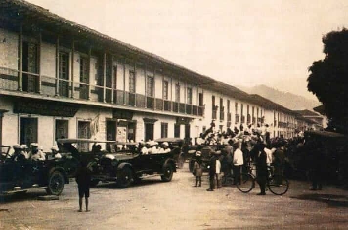 a black and white photo of a group of people standing in front of a building .