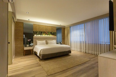 a hotel room with a large bed and a large window - 