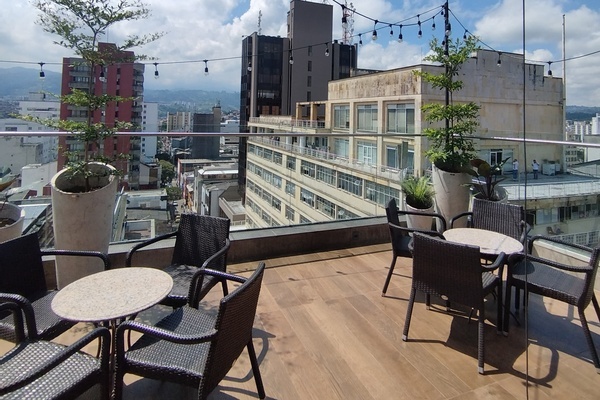 una terraza con mesas y sillas con una vista de la ciudad