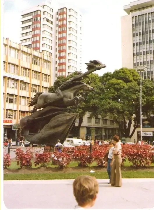 una plaza con una estatua de un caballo en el fondo