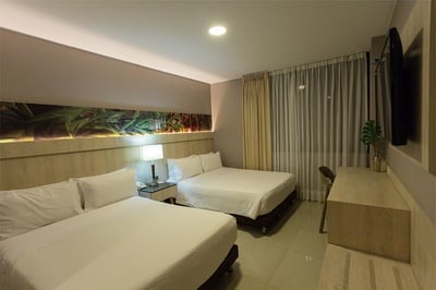 una habitación de hotel con dos camas y una mesa - 