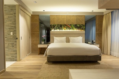 a hotel room with a bed and a painting on the wall - 