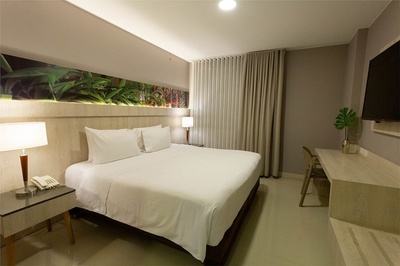 a hotel room with a king size bed and a flat screen tv - 