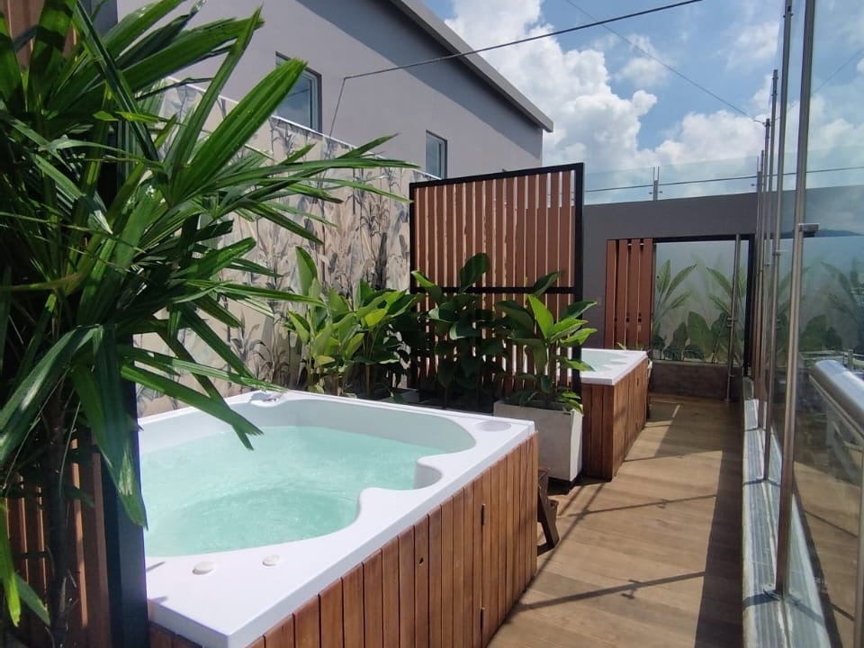 dos jacuzzis junto a una pared de madera y plantas