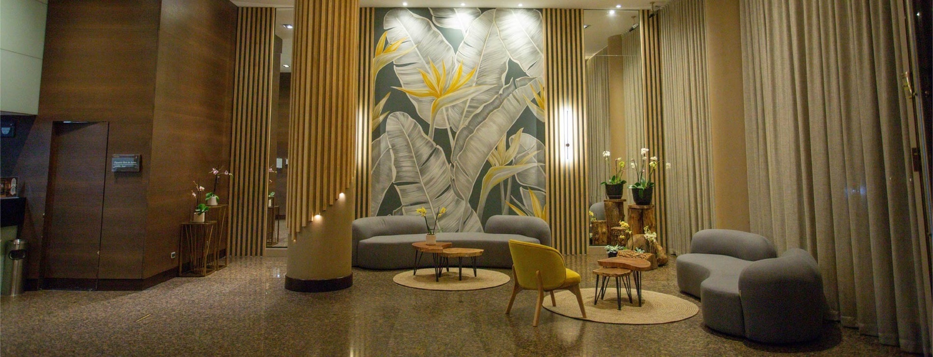 a lobby with a painting of leaves on the wall