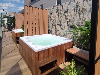 a hot tub with a wooden fence surrounding it - 