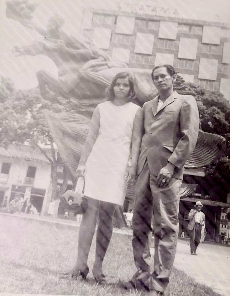 a black and white photo of a man and woman standing in front of a building that says xtcatama