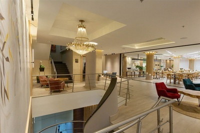 una escalera conduce a un comedor con mesas y sillas - 