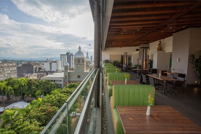 a view of a city from a restaurant with tables and chairs - 