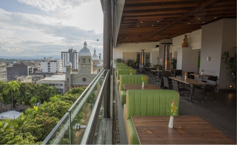 a view of a city from a restaurant with tables and chairs