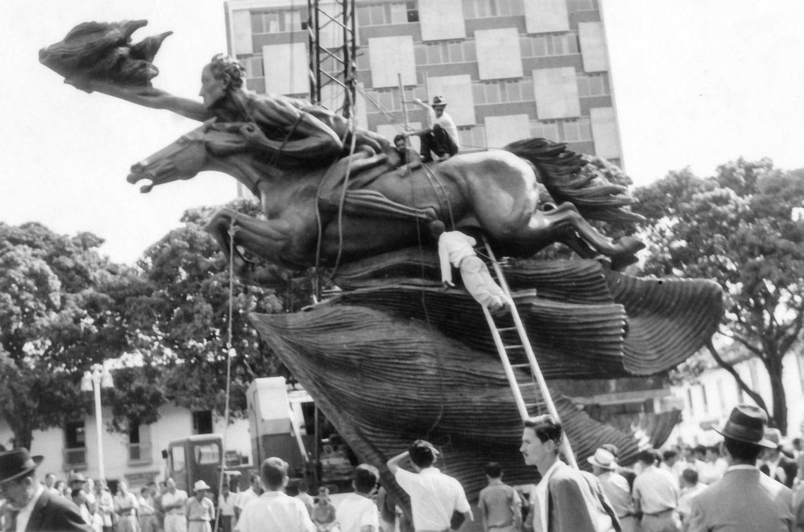 un hombre sube una escalera a una estatua de un caballo