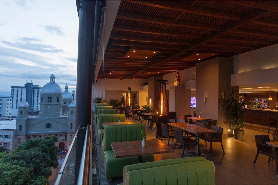 a view of a city from a restaurant with tables and chairs