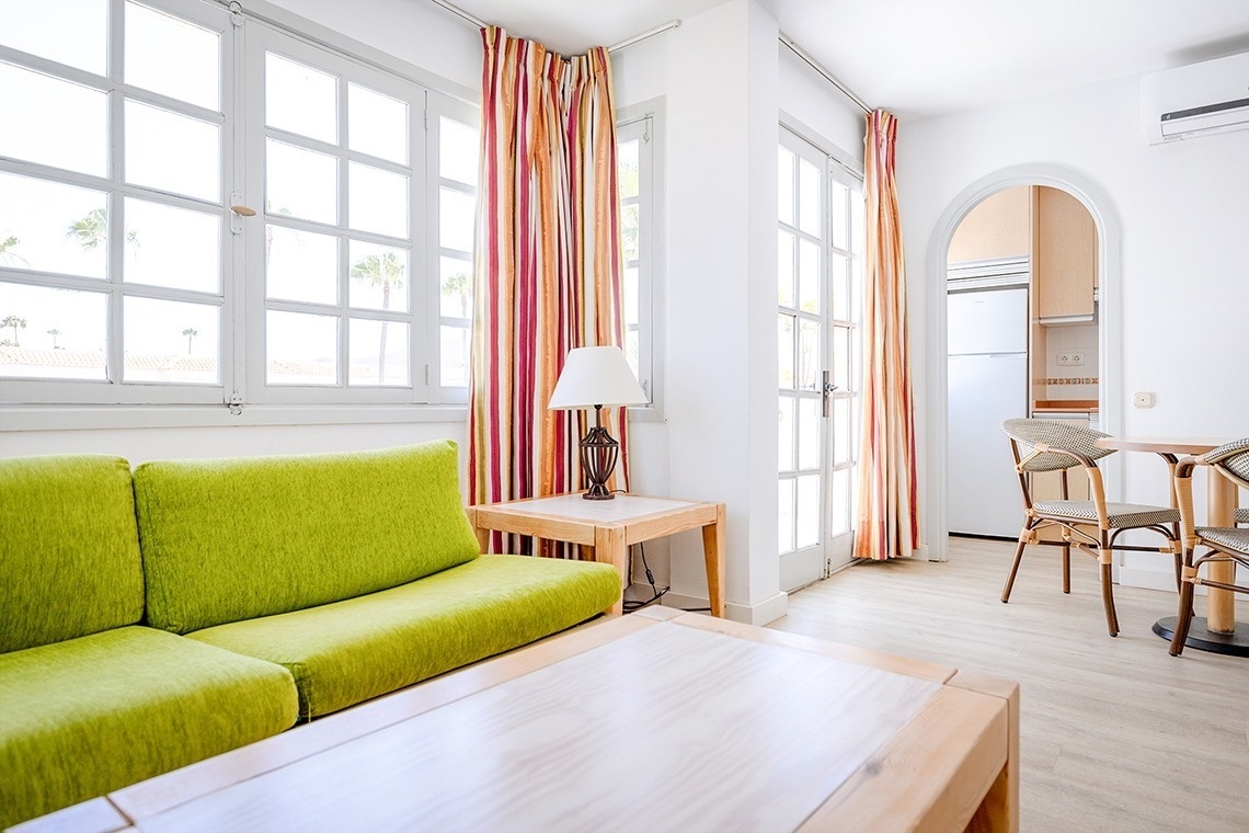 a living room with a green couch and a lamp