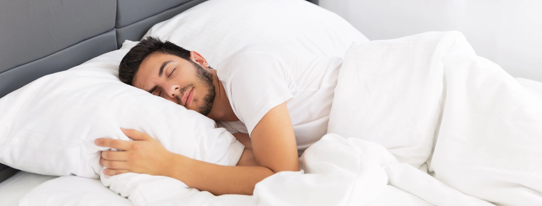 Hombre durmiendo plácidamente en una cama cómoda en Habitaciones | SNÖ Hotel Beret | Vielha - Betrén.
