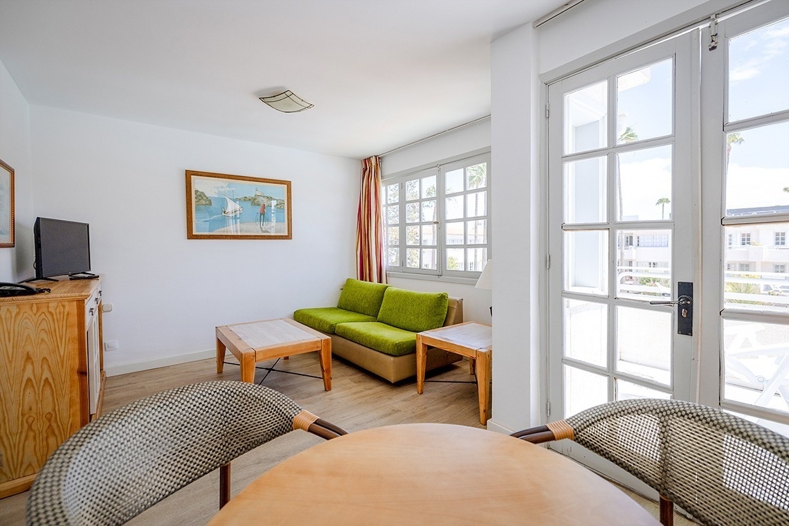 a living room with a green couch and a picture on the wall